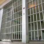Florida’s Grim Double: Two Old Men, One Day Empty prison cell with metal bars and toilet.