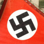 Close-up of a red flag featuring a black swastika symbol