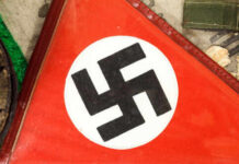 Nazi Shrine Flip: Police Move In Close-up of a red flag featuring a black swastika symbol