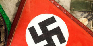Close-up of a red flag featuring a black swastika symbol