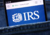 Trump’s IRS Immunity Deal SHREDDED In Court Smartphone showing IRS website in a denim pocket