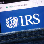 Trump’s IRS Immunity Deal SHREDDED In Court Smartphone showing IRS website in a denim pocket