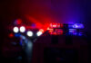 Toddler Horror Spurs Border Fury Police car lights shining in the dark.