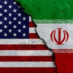 Iran Missiles Kill Americans — What Now? A cracked surface displaying the flags of the USA and Iran