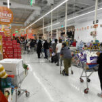 Customers waiting in line at a supermarket checkout.