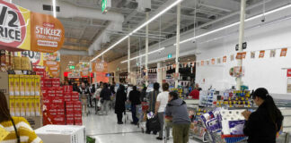 Customers waiting in line at a supermarket checkout.