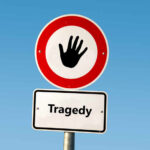 Road sign with hand stop symbol and a lower sign reading Tragedy