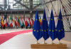 Trump Threatens NATO Shock: Troops Gone? EU flags and European flags on the background.