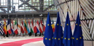 EU flags and European flags on the background.