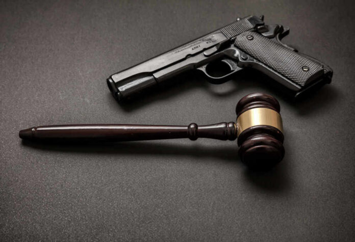 Law,,Crime,,Punishment,Concept.,Judge,Gavel,And,A,9mm,Pistol Pistol and judge's gavel on dark surface