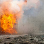Holiday Blast Turns Deadly A large explosion with flames and smoke.