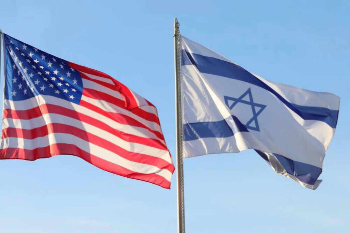 shutterstock_2225551907 American and Israeli flags waving against a clear sky.