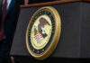 DOJ Backs Down — $722M Case Vanishes Department of Justice seal on a podium.