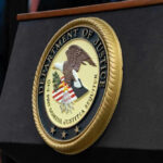 DOJ Backs Down — $722M Case Vanishes Department of Justice seal on a podium.