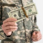 Military personnel holding a bundle of cash