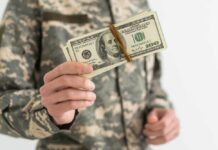 Military personnel holding a bundle of cash