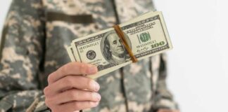 Military personnel holding a bundle of cash