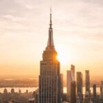 Empire State SHOCKER: Spire Breach Sparks Felonies New York City skyline at dusk with skyscrapers.