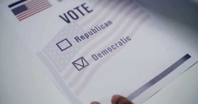 Close,Up,Of,Anonymous,Us,Citizen,Placing,Paper,Ballot,On Voting ballot with options for Republican and Democratic parties