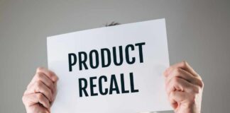 Person holding a sign reading product recall