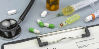 Medical supplies including a stethoscope, syringes, and medication related to measles