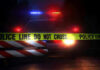 Weekend Bloodbath, Murky Math Police car with flashing lights behind caution tape.