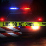 Weekend Bloodbath, Murky Math Police car with flashing lights behind caution tape.