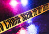 Burger Bloodbath Sparks Uncomfortable Questions Crime scene tape with flashing lights in background.