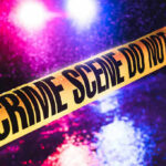 Burger Bloodbath Sparks Uncomfortable Questions Crime scene tape with flashing lights in background.