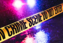 Burger Bloodbath Sparks Uncomfortable Questions Crime scene tape with flashing lights in background.