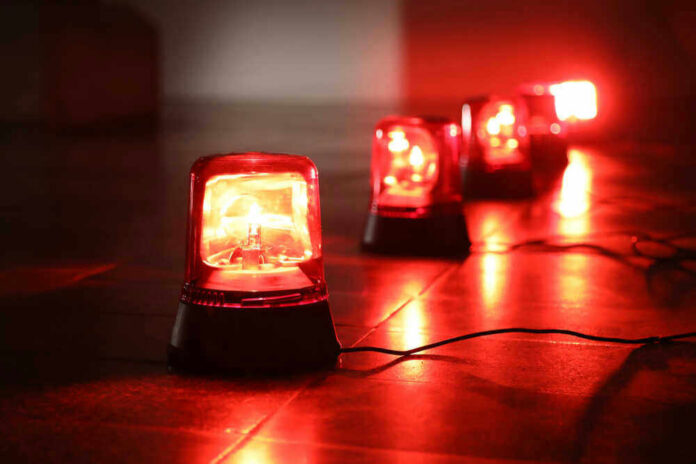shutterstock_1042134532 Red emergency lights on dark floor, illuminating the area.