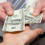 Hidden Cash Mania Explodes Nationwide Two hands exchanging cash bills