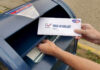 Ballot Gatekeepers: USPS Grabs the Lever Hands mailing a ballot envelope into a blue mailbox