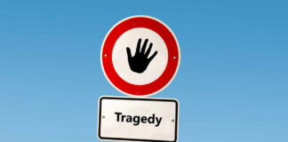 Road sign with hand stop symbol and a lower sign reading Tragedy