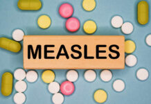 Deadly Measles Comeback Stuns Medical Community Wooden block with the word 'MEASLES' surrounded by various pills
