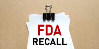 A notice labeled 'FDA RECALL' clipped to white papers on a brown background