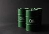 Green oil barrels on a dark background