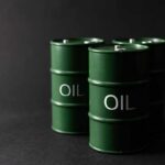 Green oil barrels on a dark background