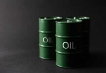 Green oil barrels on a dark background