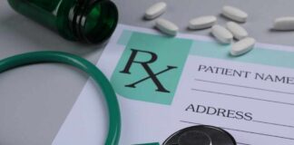 A prescription pad with a stethoscope and pills nearby