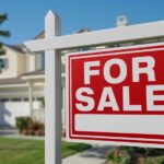 A 'For Sale' sign in front of a house