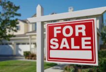 Rich Buyers Hijack Housing? A 'For Sale' sign in front of a house