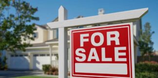 A 'For Sale' sign in front of a house