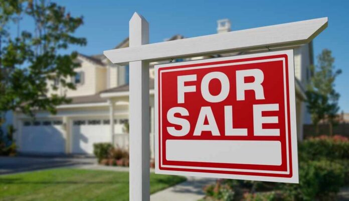A 'For Sale' sign in front of a house