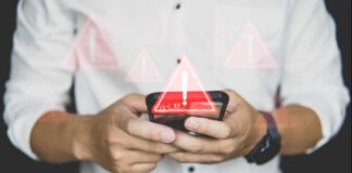 Hands holding a smartphone with warning icons overlay