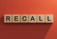 Wooden letter tiles spelling recall on an orange background