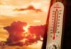 Brutal Heat Grounds Planes Thermometer displaying high temperature against a sunset background