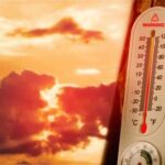 Brutal Heat Grounds Planes Thermometer displaying high temperature against a sunset background