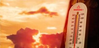 Thermometer displaying high temperature against a sunset background
