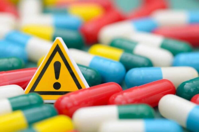 Healthcare,Safety,Warning,Concept,With,Caution,Sign,And,Medical,Capsules A prescription pad with a stethoscope and pills nearby